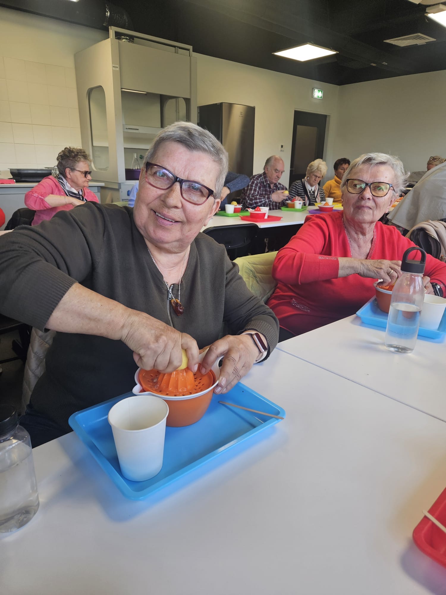 Seniorzy przygotowują napój izotoniczny podczas warszatów