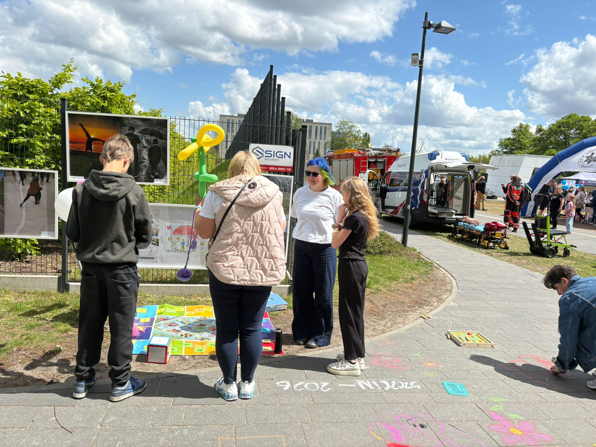 Ludzie oglądają wernisaż prac plastycznych podczas festynu